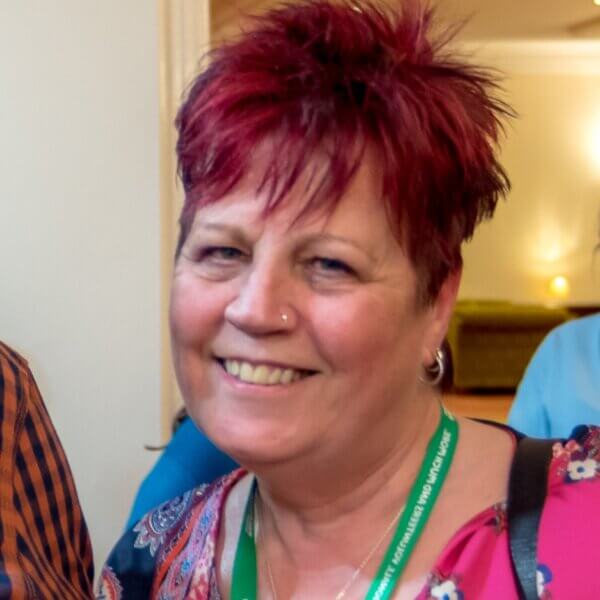 Head and shoulders of woman with short hair smiling at the camera