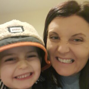 mum and young son pulling a funny smiley face to the camera