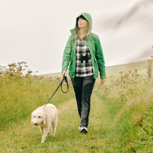 Woman walking dog in english countryside