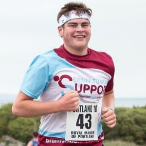 Brain Tumour Support runner, smiling, wearing charity t-shirt and bandana