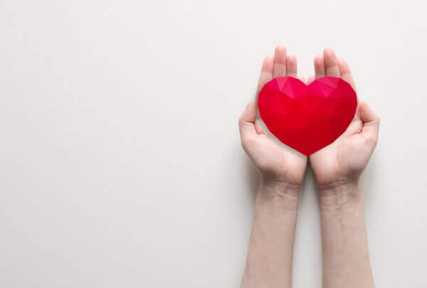 Pair of hands holding a red heart.