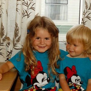 Jayde and Jenna Adams as young children both smiling and dressed in Minnie Mouse tee shirts