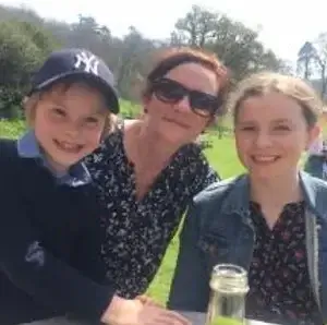 Mum and her children, a girl and boy outside and smiling towards the camera