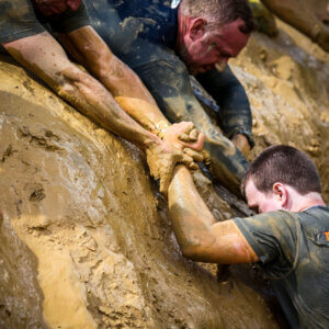 Tough Mudder teamwork in muddy obstacle challenge
