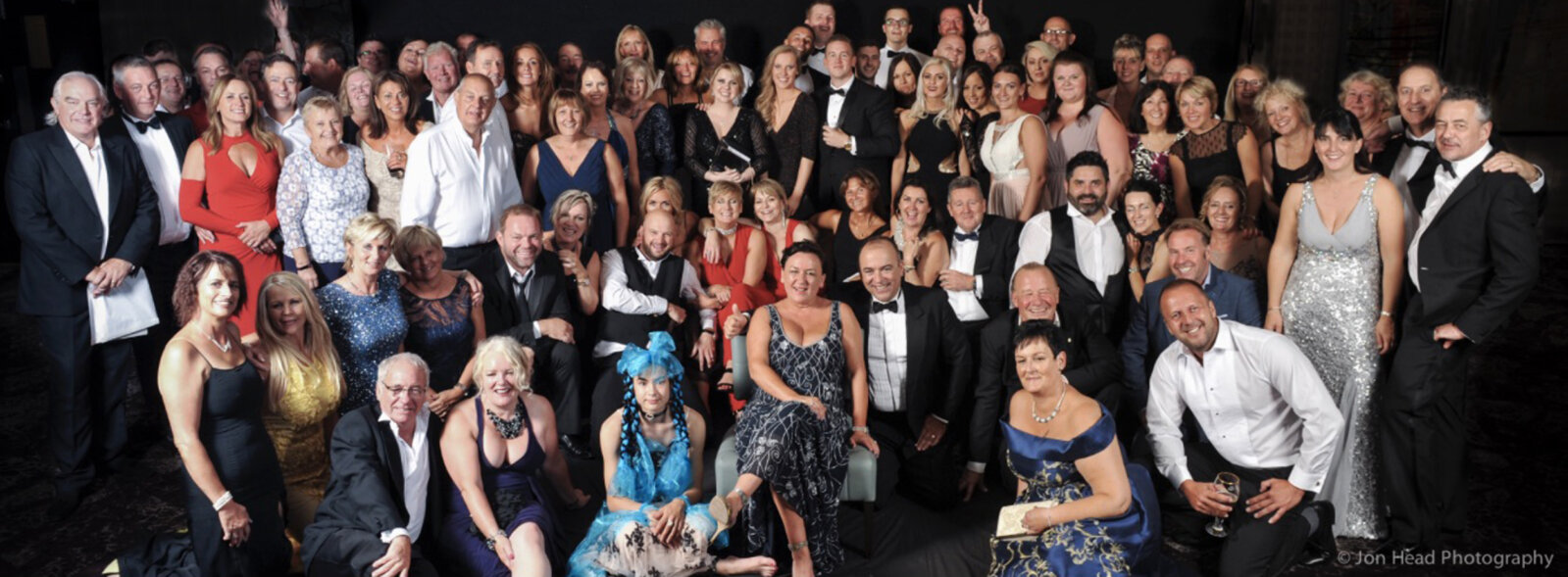 Large group photograph of people dressed smartly for a dinner and charity ball