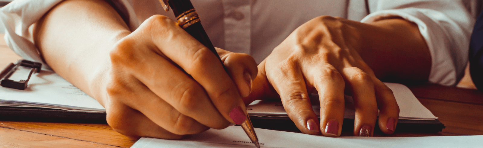 Hands signing a document
