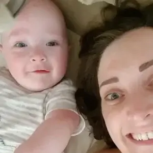 Woman with her baby both smiling at the camera