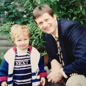 Young dad with his little boy smiling hard into the camera