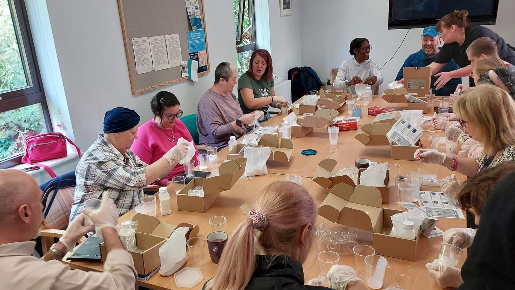 Friendly group of people sitting around table engaged in craft activity