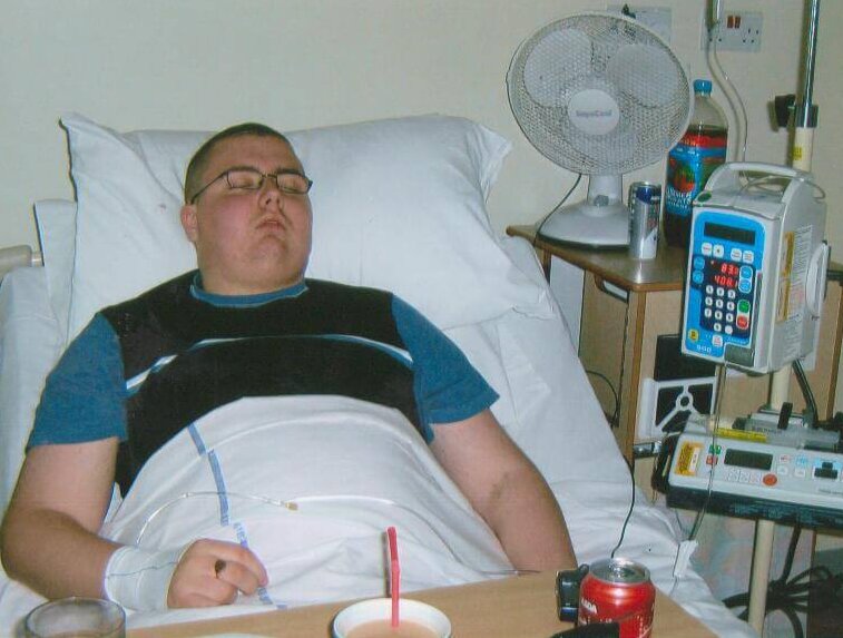 Young man sleeping in hospital bed with medical equipment around