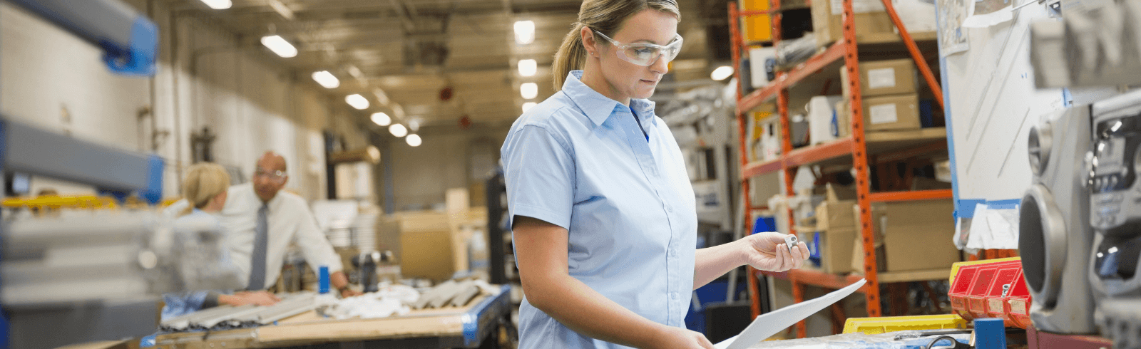 Young woman worker reviewing document in factory
