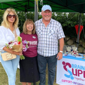 People standing in front of charity fundraising stall, smiling