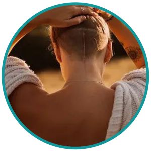 Image in a circle showing a young woman exposing her brain tumour surgery scars