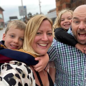 David and wife Tracy with their young children, arms wrapped around them having fun