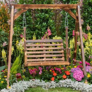Wooden garden swing surrounded by colourful flower borders