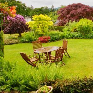 A wooden table and chairs in pretty garden