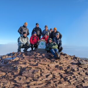 Image shows a group of people fundraising for charity by climbing the peaks