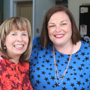 Tina Mitchell Skinner and Emma McKeown standing together, arm around shoulder, smiling