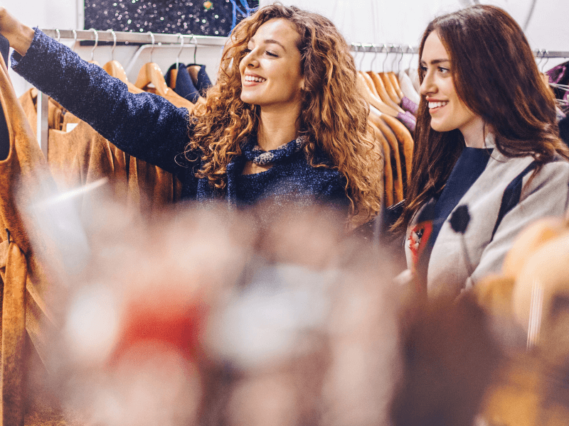 Two young women shopping for clothes together