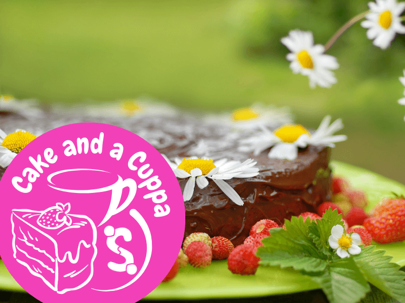 Image shows a summer chocolate cake with fresh strawberries and daisies