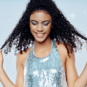 Sparkle Day fundraising event for Brain Tumour Support. Young woman looking down but smiling and happy in a glittery blue top against blue backdrop