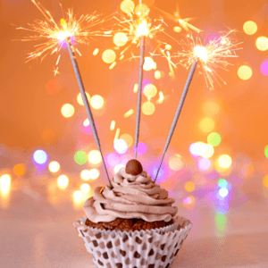 Sparkle Day fundraising. A sparkling cupcake with fancy frosting and three sparklers. Bake for Sparkle Day and raise funds for Brain Tumour Support.
