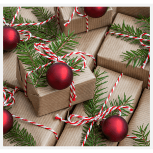 Image shows a bundle of Christmas gifts wrapped in brown paper and tied with red and white string with festive foliage and a red bauble