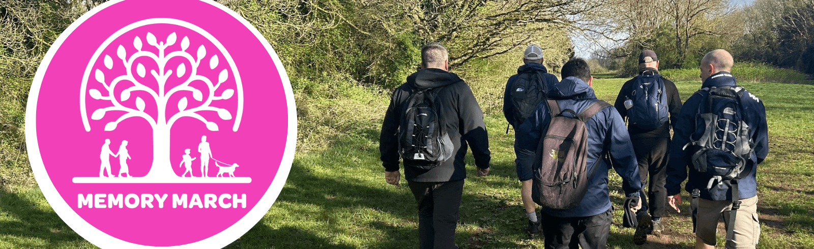 Memory March logo and group of men with rucksacks walking away in the countryside