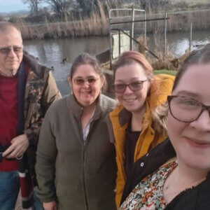 Philip and Ruth Lough with their two adult daughters beside them, standing by riverside