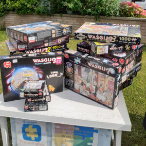 Jigsaw puzzles piled on plastic table in garden