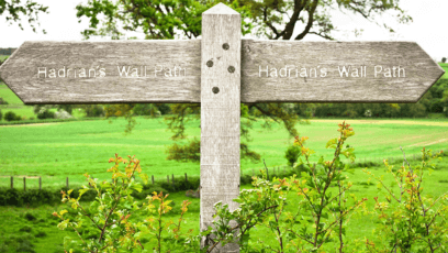 Image shows the wording on a countryside signpost pointing to Hadrian's Wall