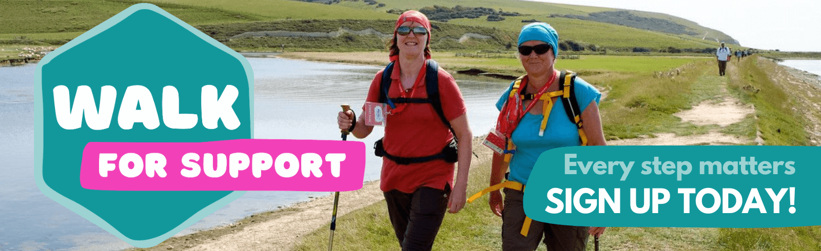 Two walkers with backpacks and walking poles taking part in Walk for Support along a scenic outdoor route.