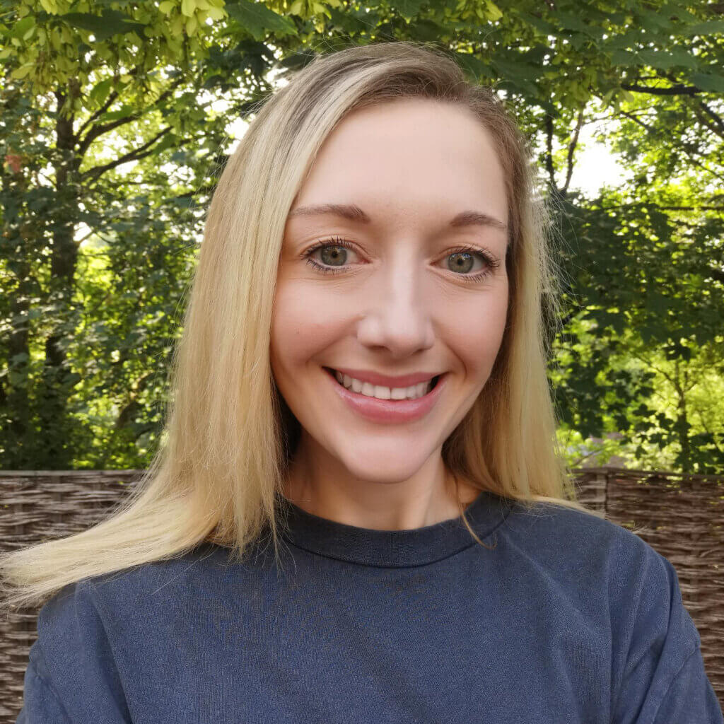 Profile picture of woman with long, straight, blond hair and wearing a blue top, smiling towards the camera